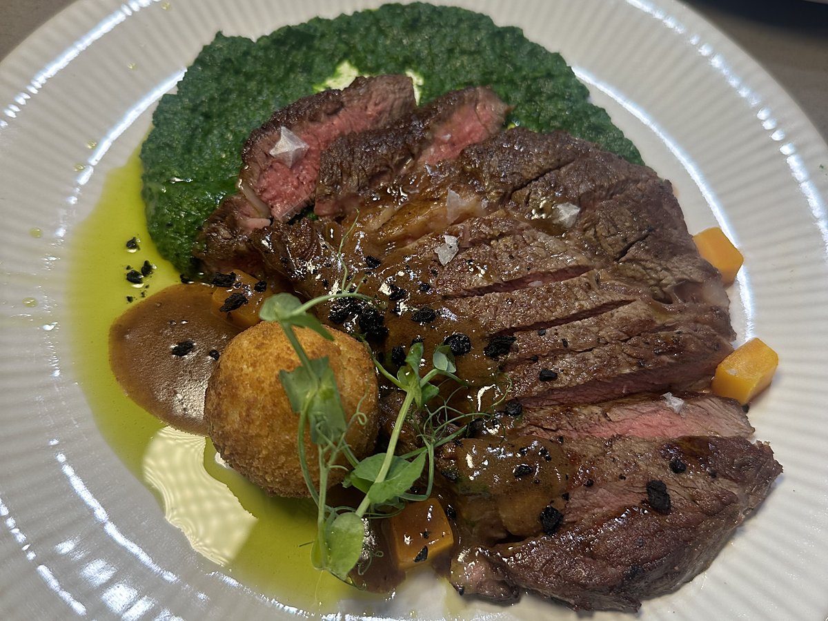 Sliced steak with herb purée and a croquette