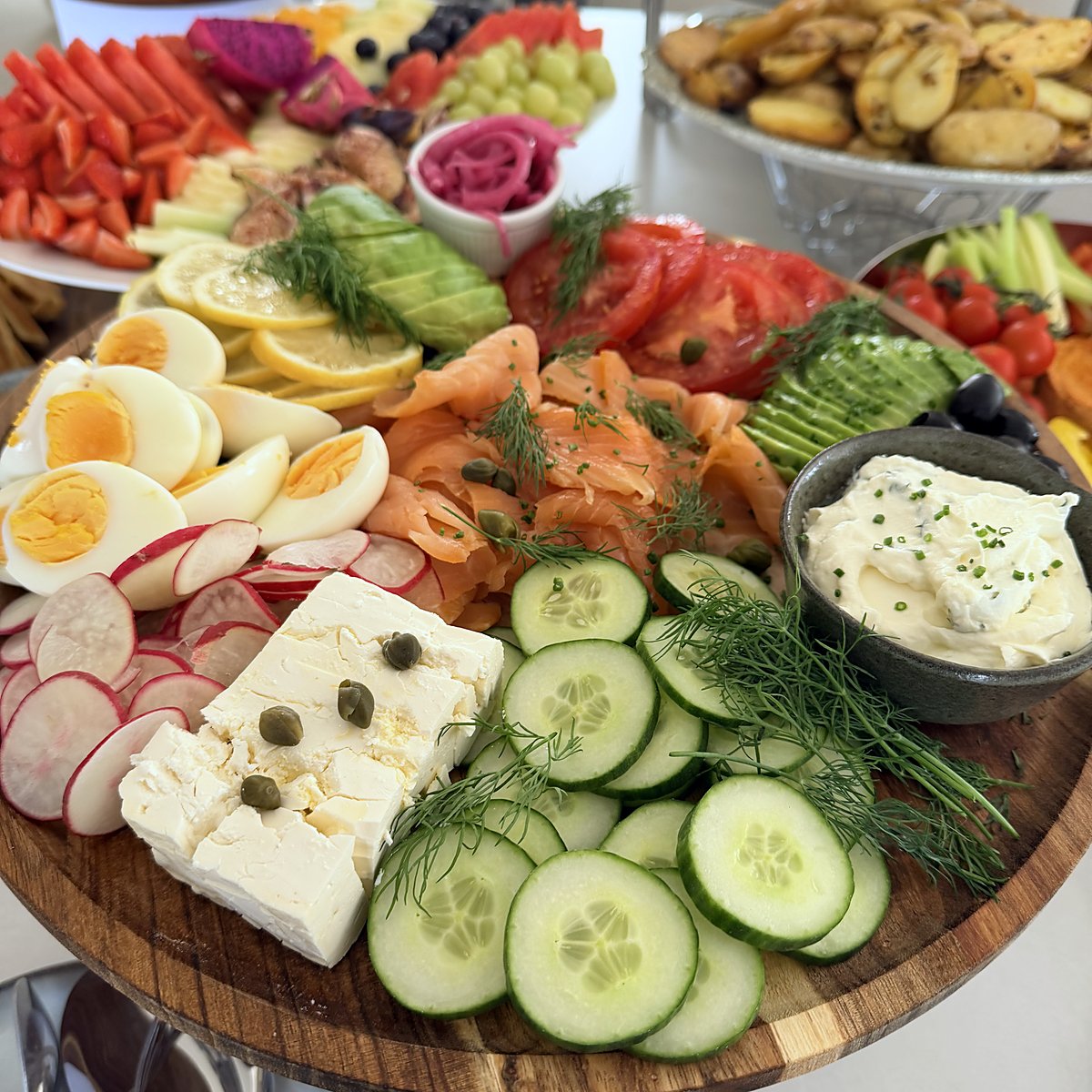 A sharing board with smoked salmon, eggs, feta and cucumber