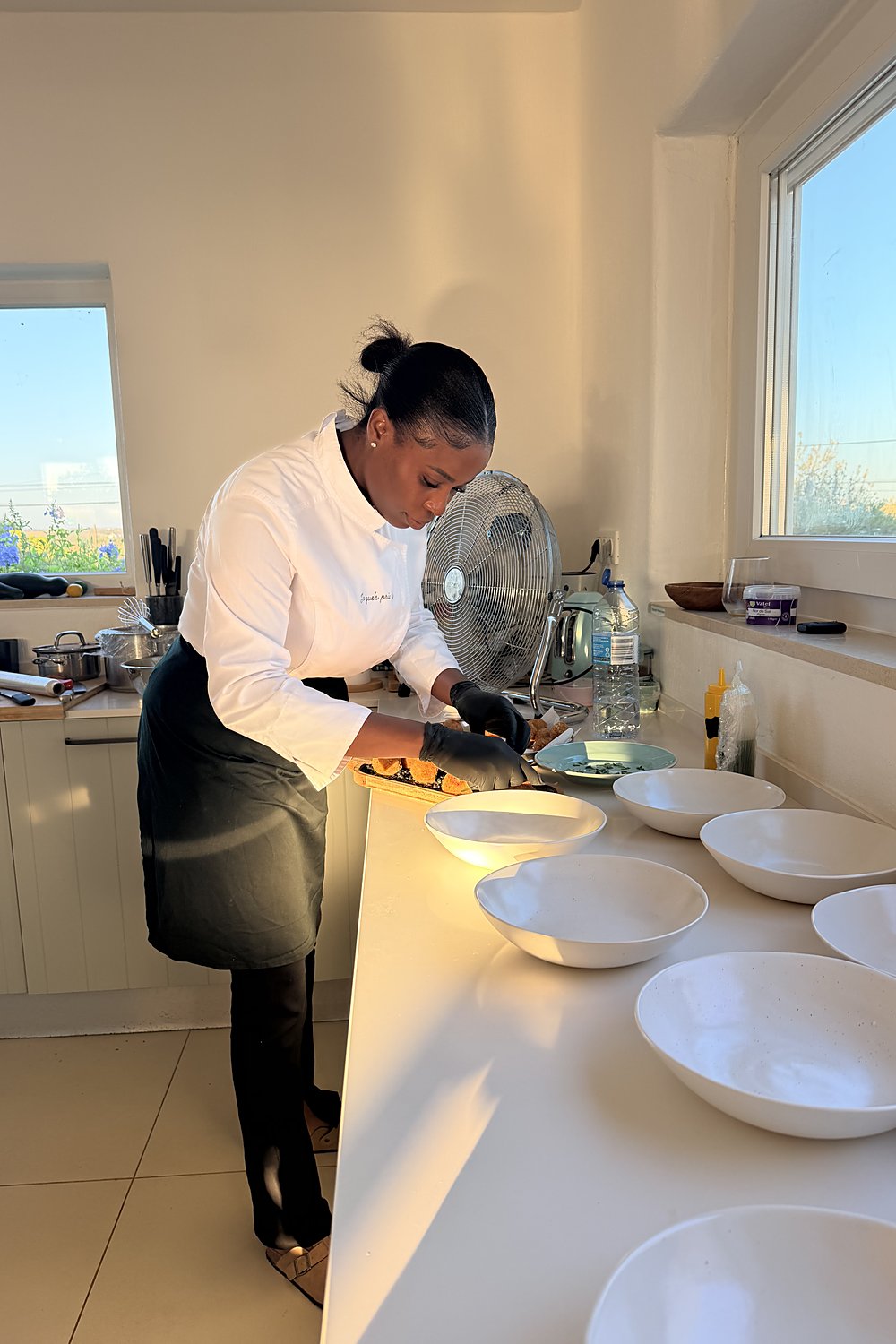 Chefa Jaquelina plating dishes at a kitchen counter