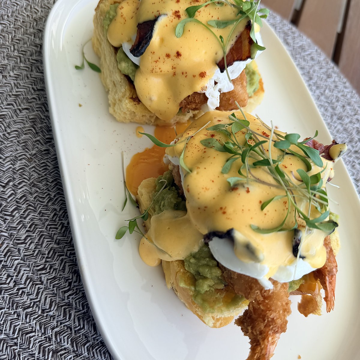 Eggs Benedict with hollandaise, avocado and fresh herbs
