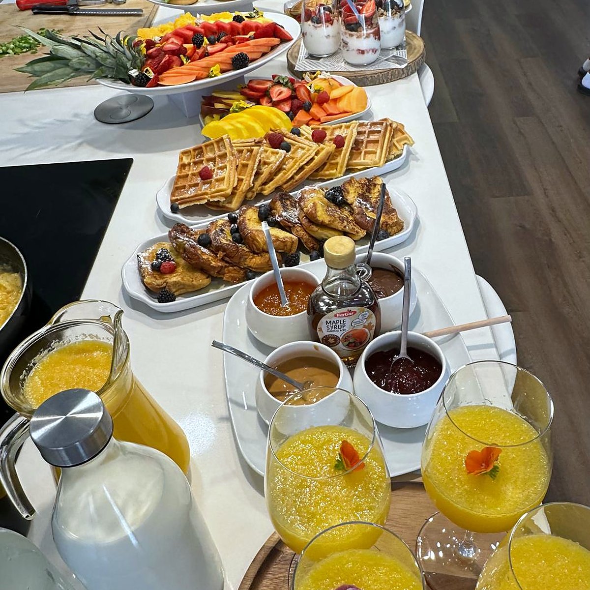 A brunch table with pastries, fruit and fresh orange juice