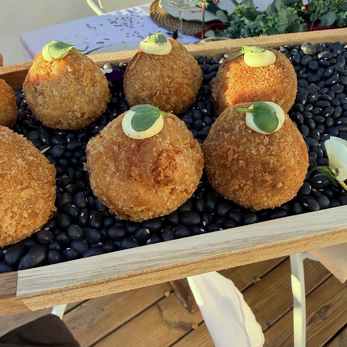 Golden croquettes on a bed of black stones