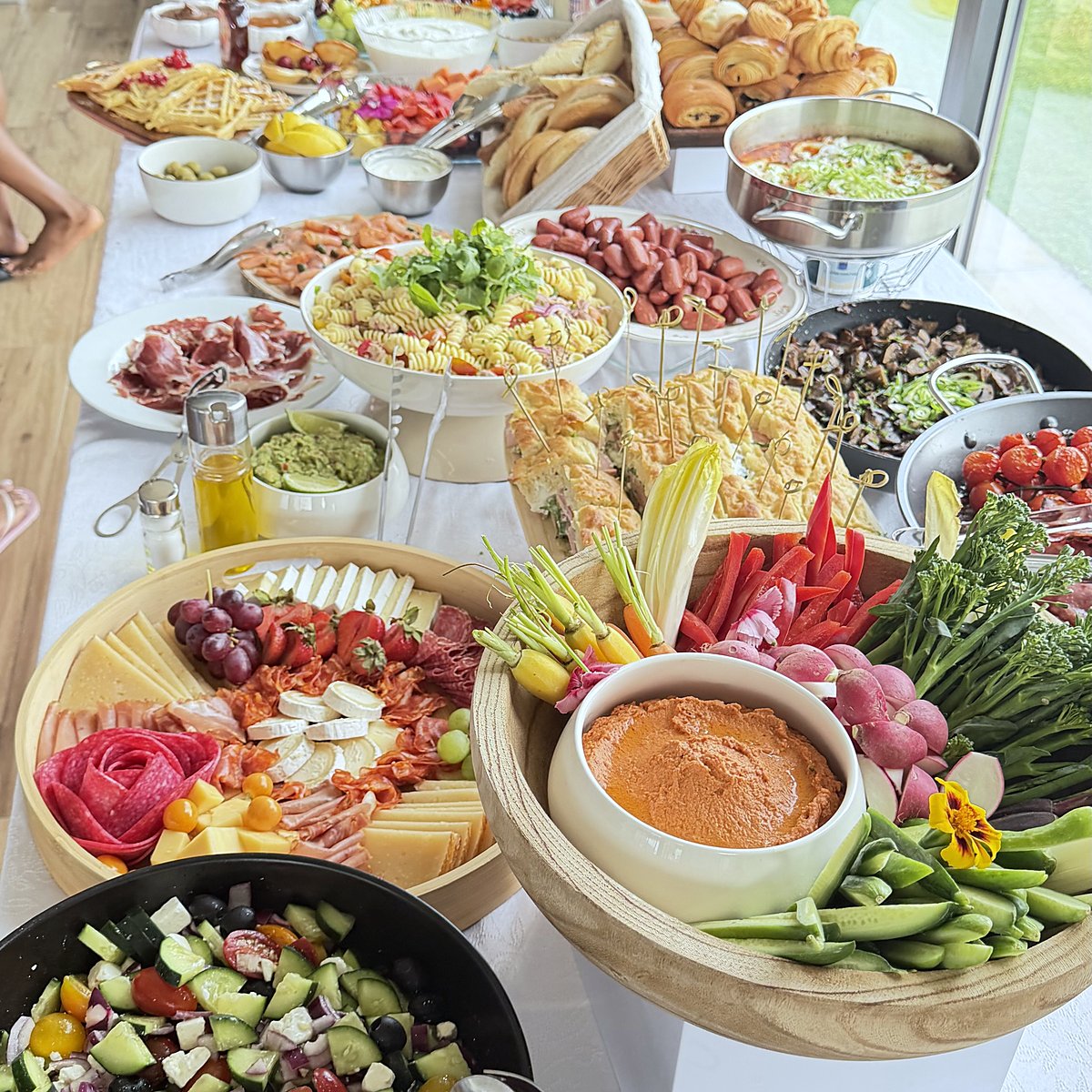 A buffet with salads, dips and fresh vegetables