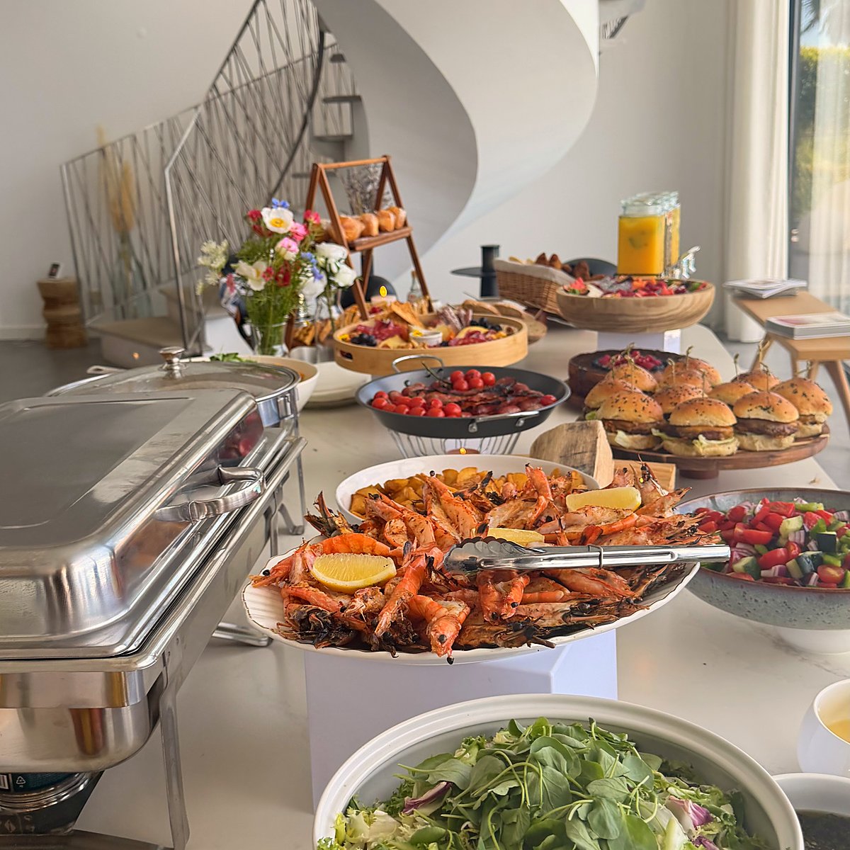 A buffet set up in a villa with chafing dishes