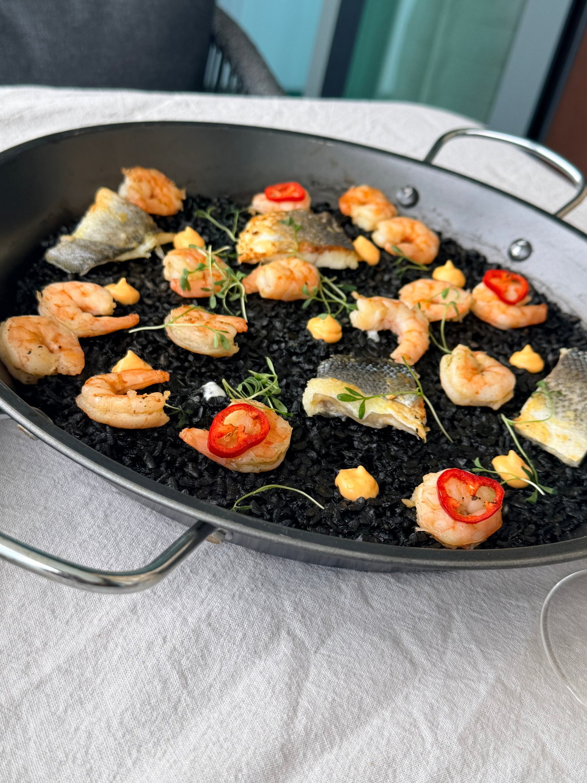Black rice with prawns and sea bass, served at the table