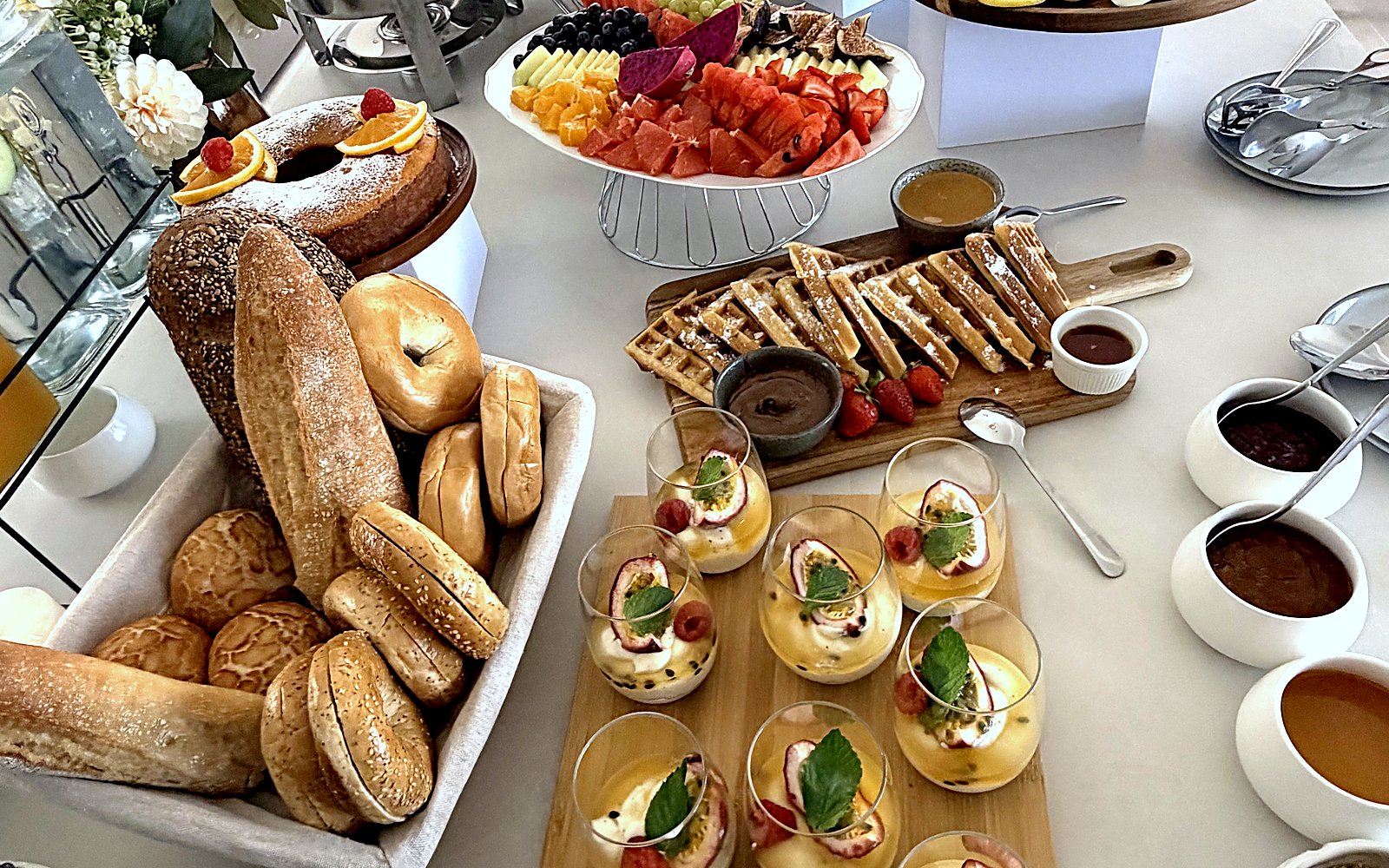 A brunch spread with bagels, pastries and fruit in a holiday home in Ferragudo