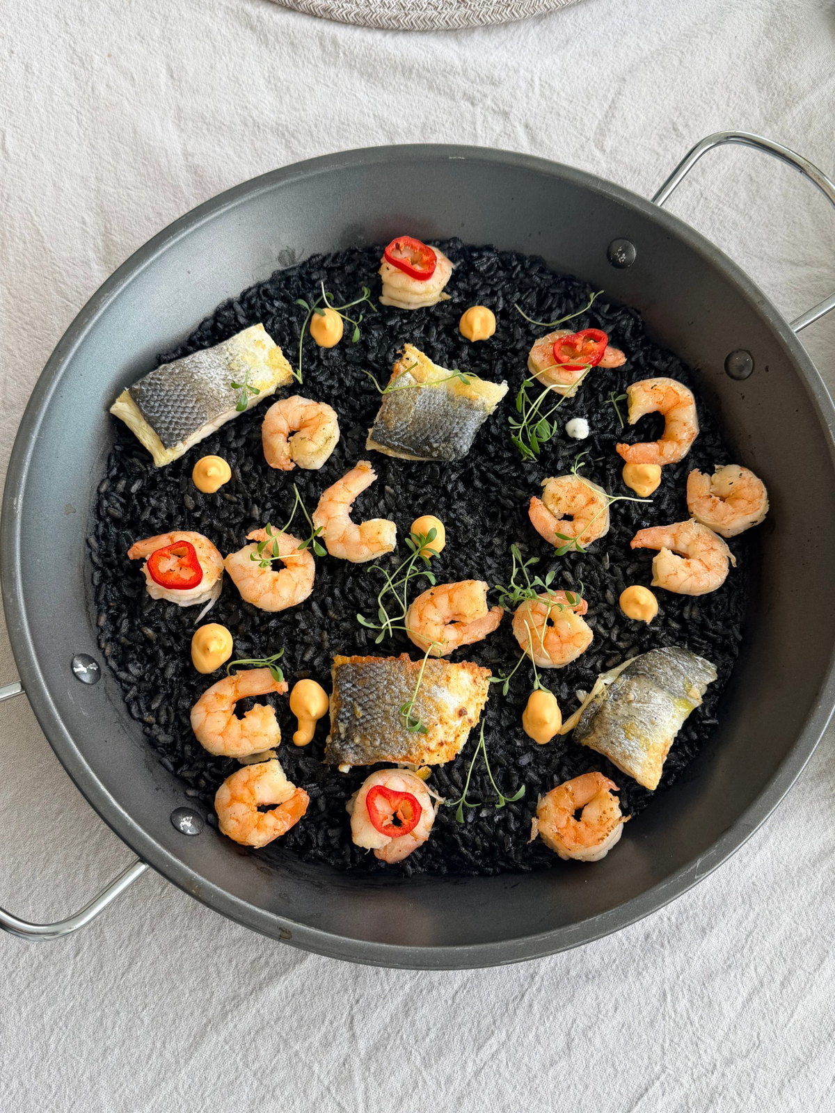 Black rice with prawns, sea bass, chilli and dots of aioli